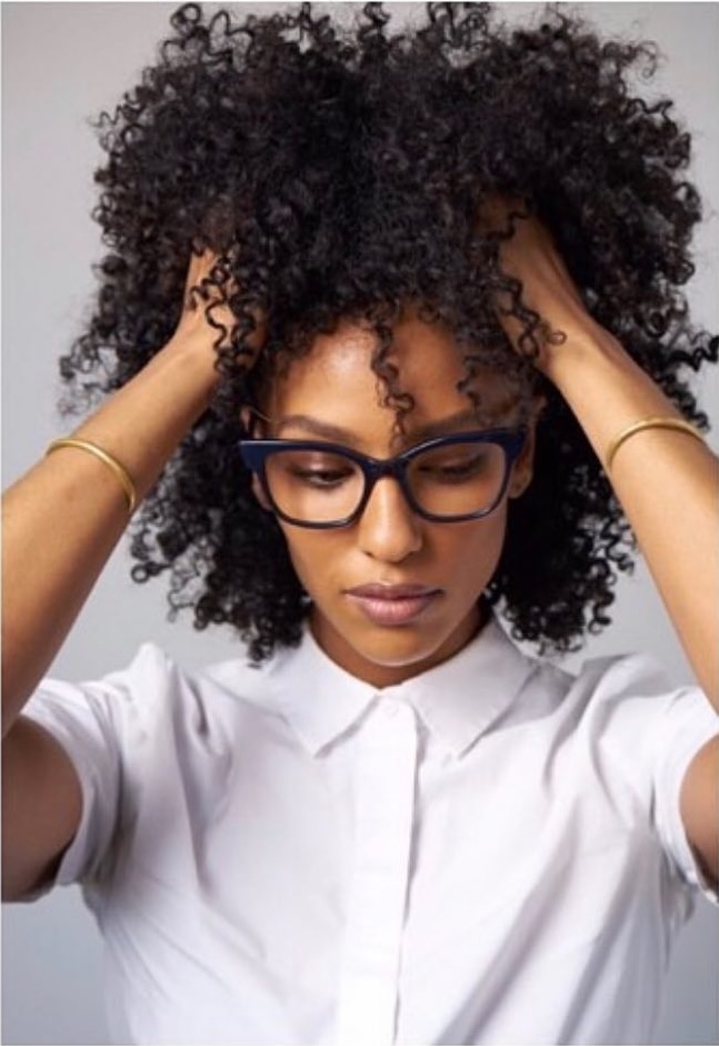 Woman in eyeglasses hands on head